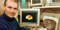 Der Neurobiologe Andreas Kreiter 1998 in seinem Labor in der Bremer Uni; auf dem Computerbildschirm hinter ihm ist gerade die Abbildung eines Gehirns zu sehen, bei dem ein Teil eingefärbt ist. Auch der Block in seinen Händen zeigt einen Gehirnquerschnitt