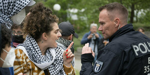 Eine Frau diskutiert während propalästinensischen Demonstration an der Freien Universität Berlin mit einem Polizeibeamten